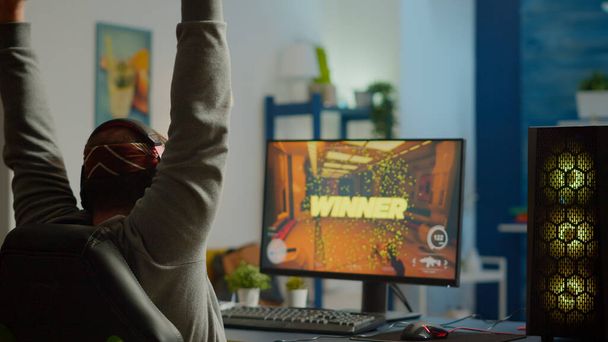 Plan arrière de l'homme heureux gamer wining jeu vidéo de tir à la première personne - Photo, image
