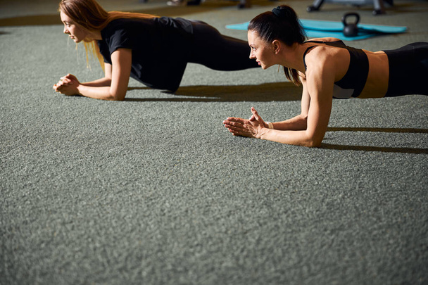 Two fit women exercising in endurance and doing planks - Foto, Bild