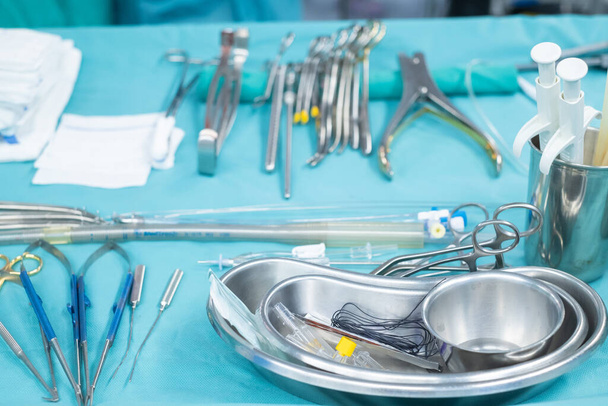 Medical team performing operation. Close up of scrub nurse taking medical instruments for operation. Medical and instrumentalist nurse working in an operating room with scissors of surgery. - Photo, Image