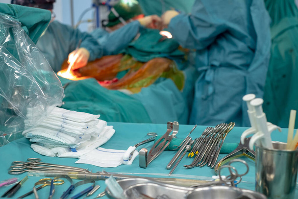 Medisch team voert operatie uit. Close-up van scrub verpleegkundige nemen van medische instrumenten voor de operatie. Medische en instrumentalistische verpleegkundige werkzaam in een operatiekamer met een schaar van chirurgie. - Foto, afbeelding