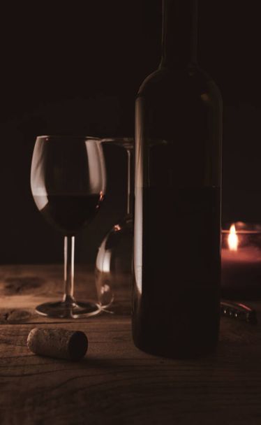 Romantic ambiance wine bottle and wine glasses with candle light - Foto, afbeelding