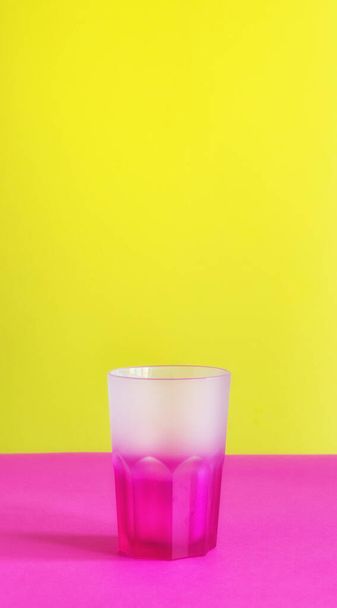 Vidrio de color de bebida vacío transparente aislado sobre fondo colorido espacio de copia minimalista maqueta - Foto, imagen
