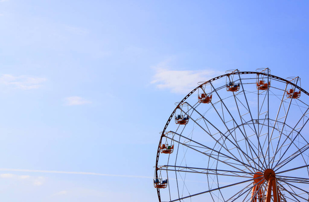 Экскурсионное колесо в парке развлечений на фоне голубого неба с текстовым пространством - Фото, изображение