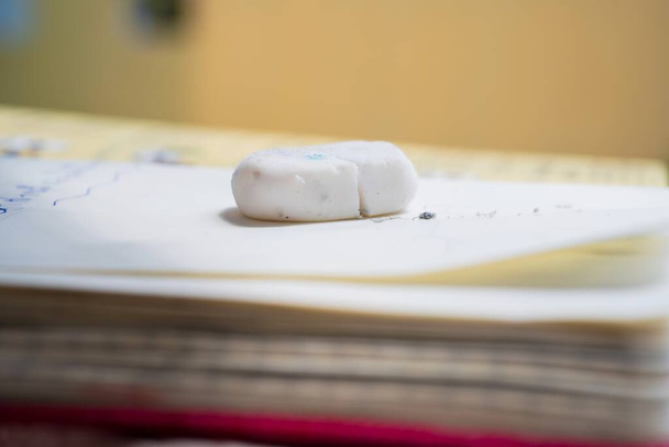 Close-up de borracha branca usada e resíduo no fundo do livro - Foto, Imagem