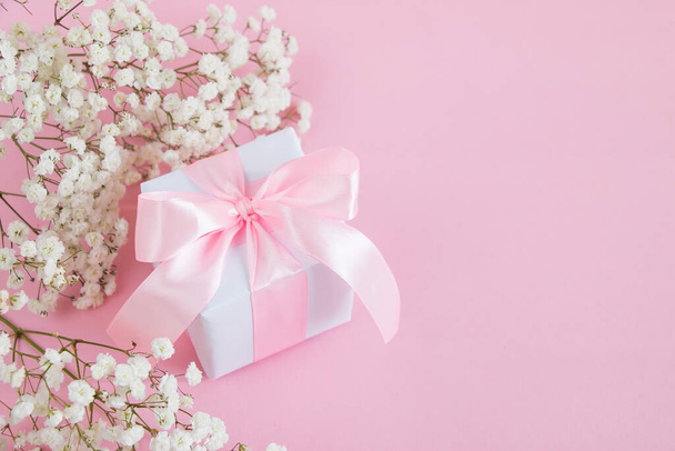 Ajándékdoboz és egy csokor virágzó cigányvirág rózsaszín háttérrel. Anyák napi ünnepi fogalom. Fénymásolási hely. - Fotó, kép
