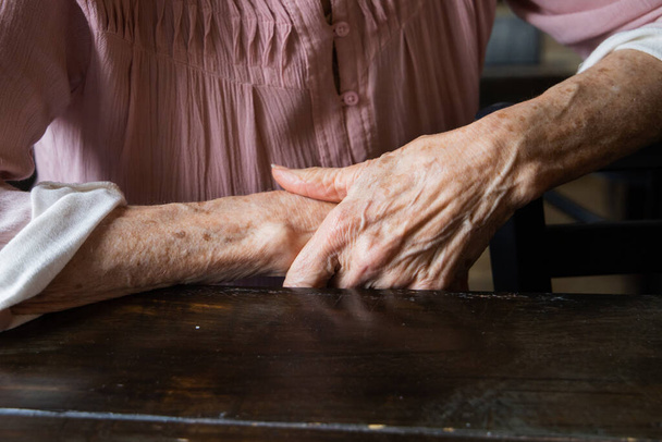 A pair of elderly woman grandmothers hands folded and laying on top of each other. - Foto, Imagen