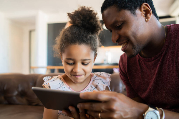 Vater und Tochter nutzen digitales Tablet zu Hause. - Foto, Bild