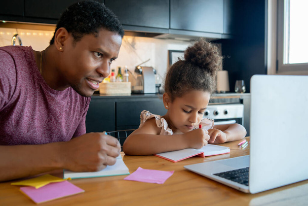 A father helping his daughter with homeschool. - Foto, Bild