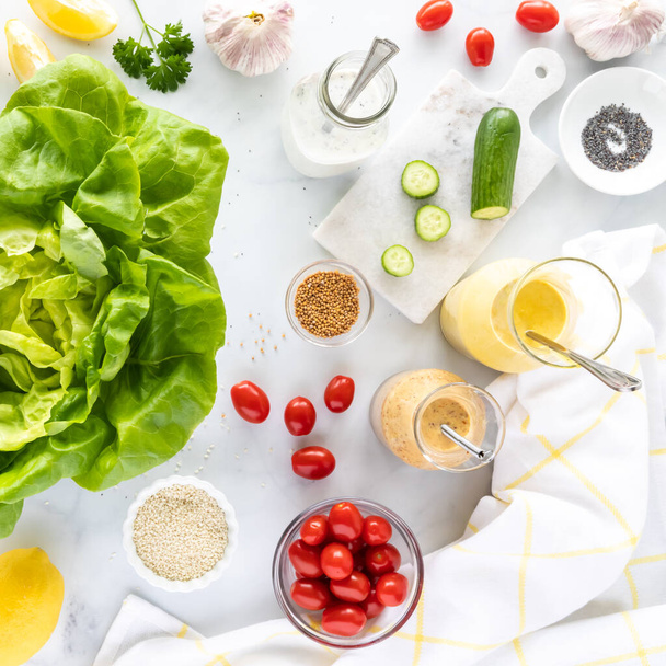 Vista dall'alto verso il basso di vari ingredienti utilizzati per fare insalata e condimento per insalata fatto in casa. - Foto, immagini