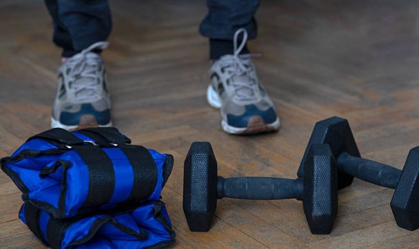 Equipment for exercising the muscles of the arms and legs. Weights and sandbags on the wooden floor - Photo, Image