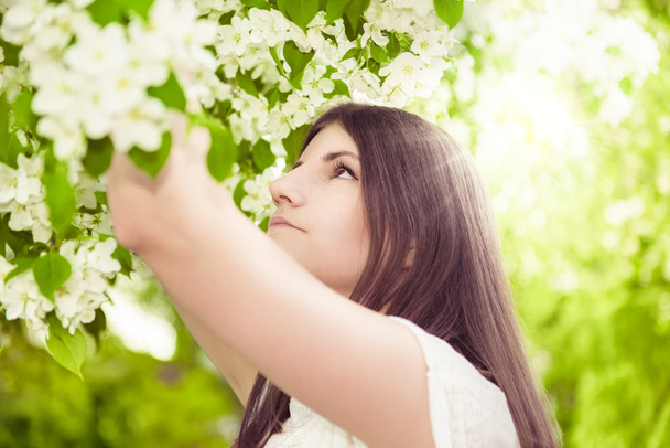 μελαχρινή κοπέλα όμορφη άνοιξη στον ανθισμένο κήπο - Φωτογραφία, εικόνα