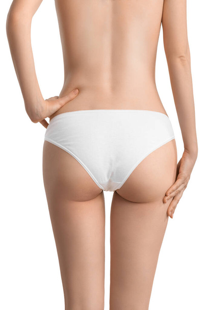 A slender girl in classic white underwear shows off her waist and toned buttocks. The concept of diet, exercise, body care or getting rid of cellulite - Photo, Image