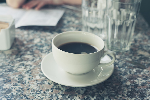 Cup of coffee on a table - Fotó, kép