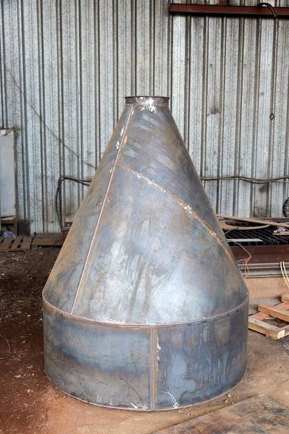 неокрашенный металлический конический бункер в мастерской - Фото, изображение