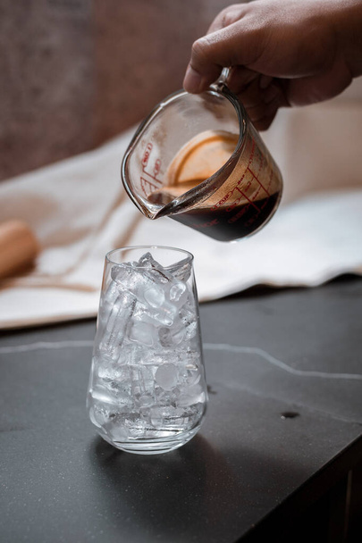 Barista vertiendo leche en un vaso de café helado - Foto, imagen