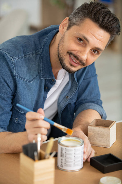 man painting a small wooden box - Φωτογραφία, εικόνα