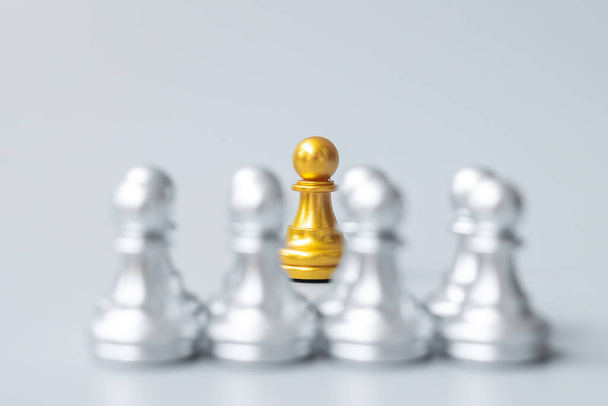 Goldene Schachfiguren oder ein führender Geschäftsmann heben sich von der Masse der silbernen Männer ab. Führung, Geschäft, Team, Teamwork und Personalmanagement-Konzept - Foto, Bild