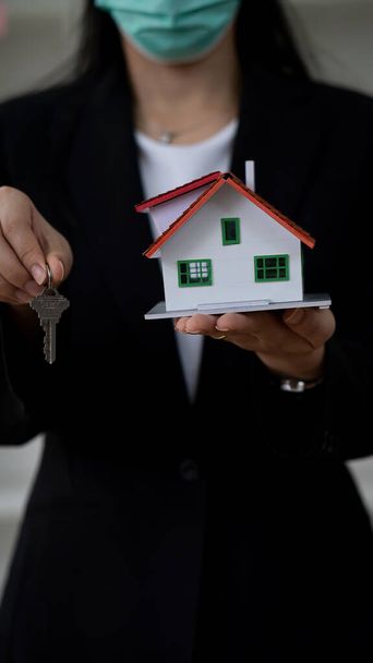 Immobilienmakler raten Kunden, Häuser mit Vertragsunterlagen und Laptop auf dem Schreibtisch zu mieten oder zu kaufen. - Foto, Bild