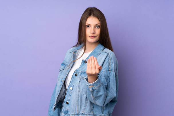 Teenager caucasian girl isolated on purple background inviting to come with hand. Happy that you came - Photo, Image