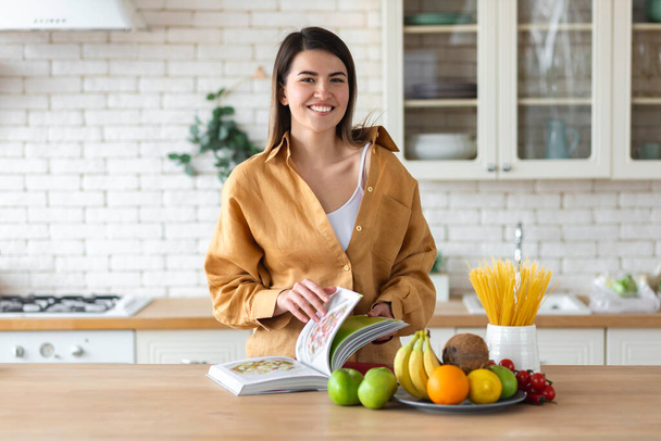 Healthy lifestyle concept. Beautiful young woman with set of food for healthy nutrition stands at home in the kitchen - Foto, Bild