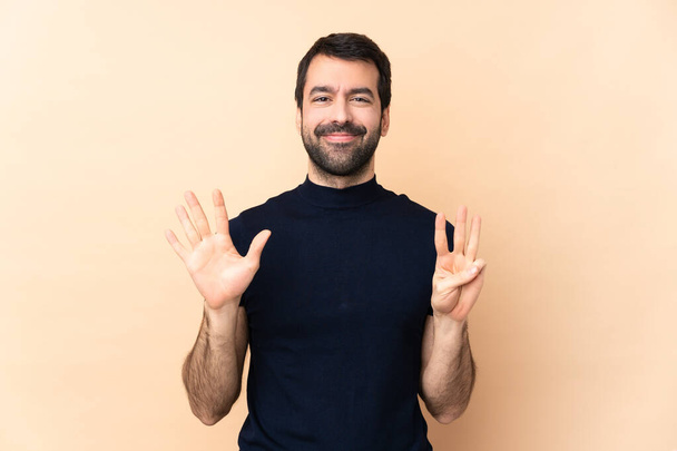 Kaukázusi jóképű férfi izolált háttér számolás nyolc ujjal - Fotó, kép