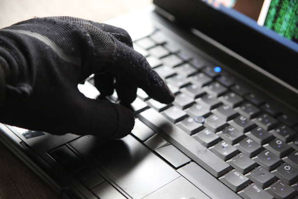 A closeup of a person in gloves using the computer - concept of cybersecurity and threat of getting hacked - Foto, Imagem