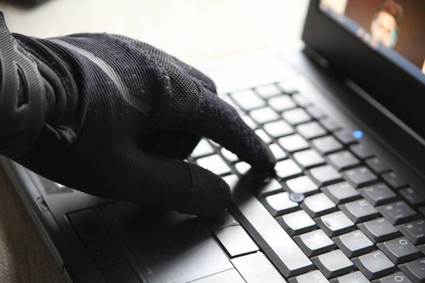 Un primer plano de una persona en guantes usando el ordenador - concepto de ciberseguridad y amenaza de ser hackeado - Foto, imagen