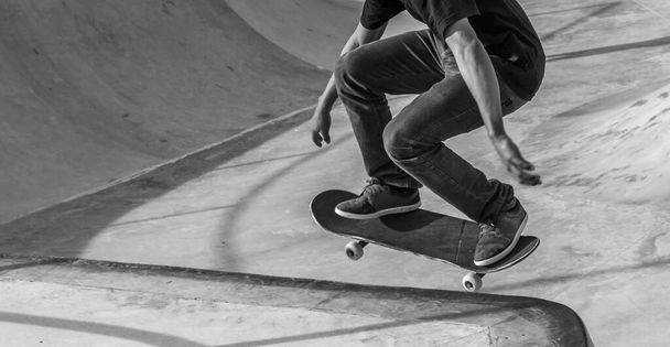 A grayscale shot of a person skating in a skatepark - Zdjęcie, obraz