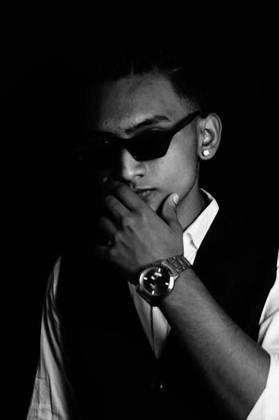 A black and white portrait of a stylish Indian man with sunglasses and in formal wear - Foto, Bild