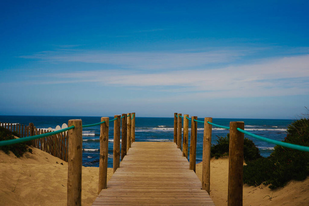 A scenic view of a wooden pathway to the sea - Photo, image