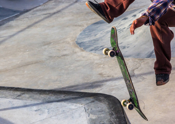 Detailní záběr na bruslaře, jak dělá kickflip v skateparku - Fotografie, Obrázek