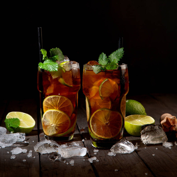 Fresh made longdrink Cuba libre cocktail on dark background. Front view, Copy space - Φωτογραφία, εικόνα