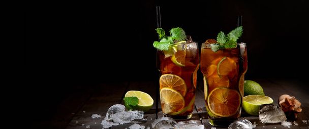 Fresh made longdrink Cuba libre cocktail on dark background. Front view, Copy space, panorama, banner - Photo, image