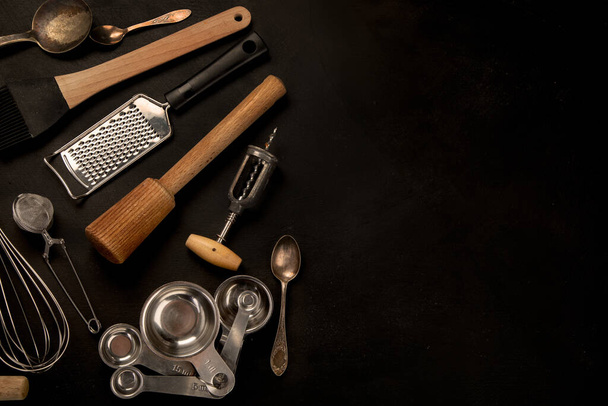 Set of kitchen utensils on black background. Tools for cooking. Top view, copy space - Foto, imagen