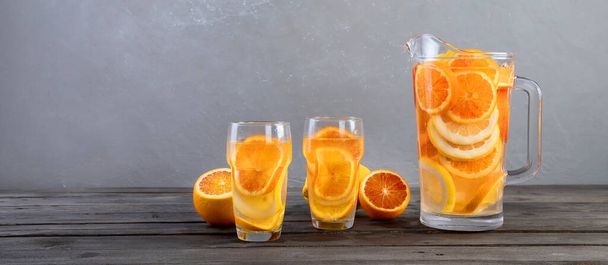 Refreshing orange lemonade on grey wooden table. Summer drinks concept. Panorama - Photo, Image