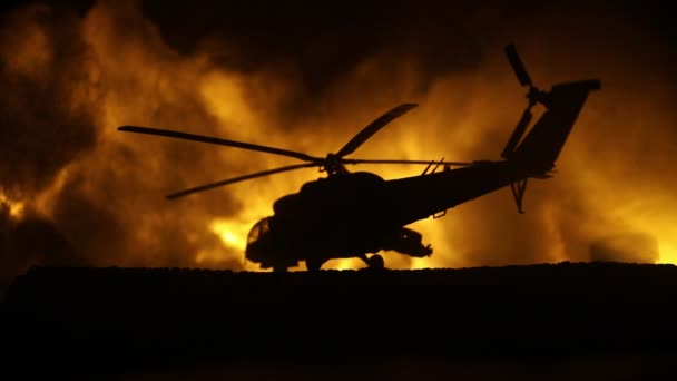 紛争地域から飛ぶ準備ができて軍事ヘリコプターのシルエット。霧を基調としたバックライト付き砂漠で始まるヘリコプターと装飾された夜の映像 - 映像、動画