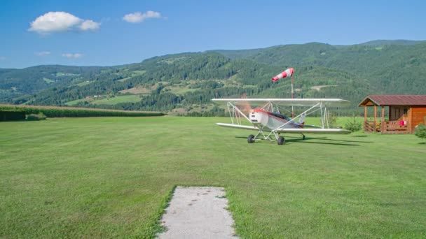 Ultrakönnyű Biplane körbeutazza a füves rétet. Karintia régió, Szlovénia. - Felvétel, videó
