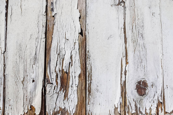 A closeup of the weathered and old white painted wooden fence - Foto, afbeelding