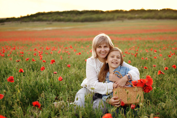 happy woman and daughter in poppy field - Φωτογραφία, εικόνα