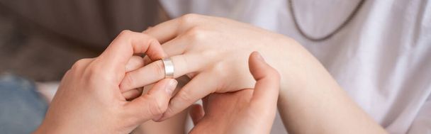 καλλιεργημένη άποψη της γυναίκας που φοράει δαχτυλίδι στο δάχτυλο της φίλης της, πανό - Φωτογραφία, εικόνα