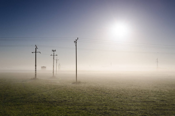 ЭНЕРГЕТИКА - Высоковольтная линия электропередач в туманном мегаполисе  - Фото, изображение