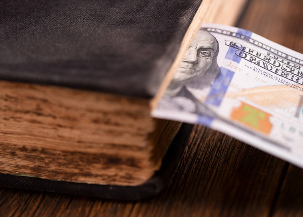 Dollar bill used as a bookmark in a book. One hundred US dollars - Fotografie, Obrázek