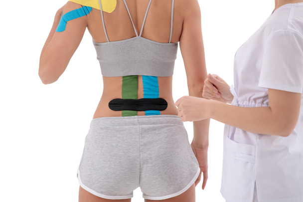 dynamic functional bandage with kinesio taping on the female back isolated on white background - Foto, imagen