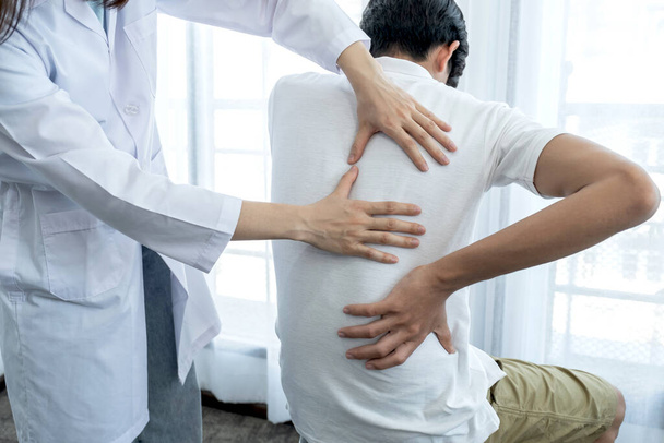 Mãos femininas fazendo fisioterapia Estendendo as costas de um paciente do sexo masculino. - Foto, Imagem