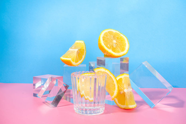 Verão limonada brilhante sobre fundo rosa azul colorido com pedestais de vidro pódios com frutas frescas, espaço de cópia  - Foto, Imagem