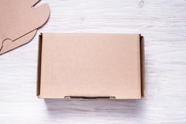 Ремесленный коричневый картонный ящик на деревянном фоне - Фото, изображение