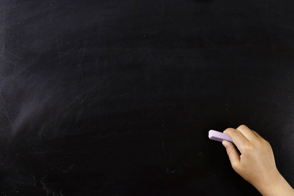 child hand draw something on empty blackboard with chalk. Space for text - Photo, Image