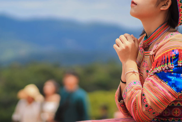 Une jeune femme montre le symbole de la prière à Dieu pour les bénédictions du Seigneur pour trouver de bonnes choses avec foi dans la sacralité et la puissance de Dieu sur le fond flou de la nature le matin. - Photo, image