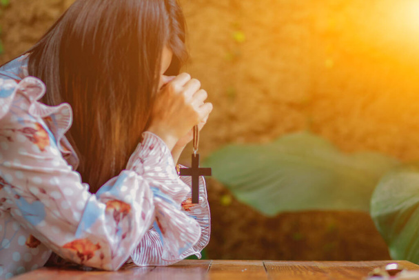 Dívka drží kříž v ruce a ukazuje symbol modlit se za požehnání Boží s nadějí a vírou v Boha, aby pomohla chránit svého milence. Koncept ducha, lásky a víry pro Boha - Fotografie, Obrázek