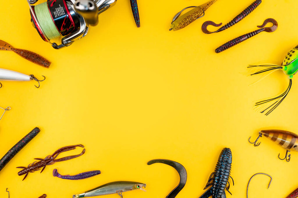 黄色のトレンディーな背景に低音釣りの概念。フラットレイアウトスタイル。釣りのタックル、柔らかいシリコンルアー、スピナー餌とぐらつき.  - 写真・画像